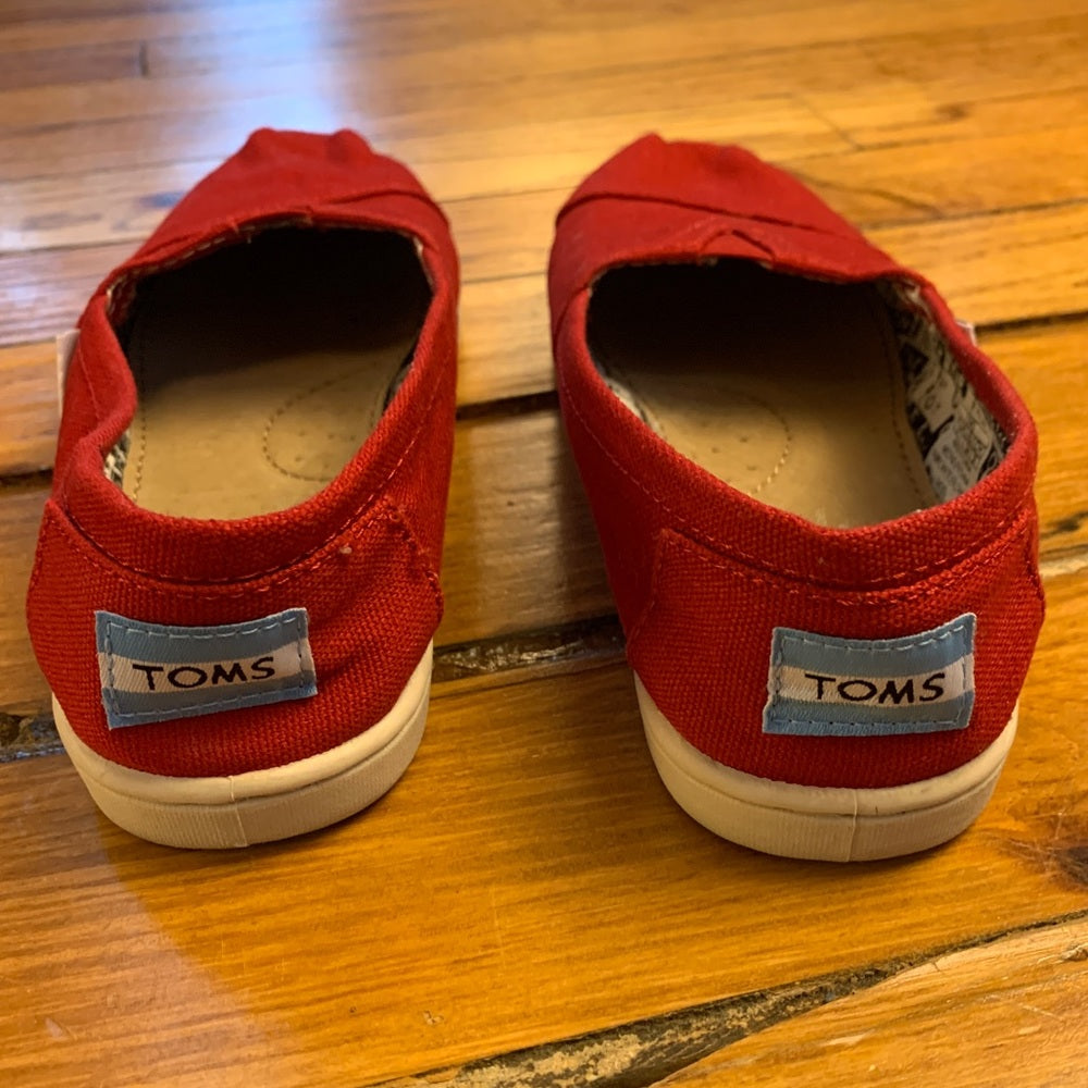 Toms red slip on canvas shoes, size 2